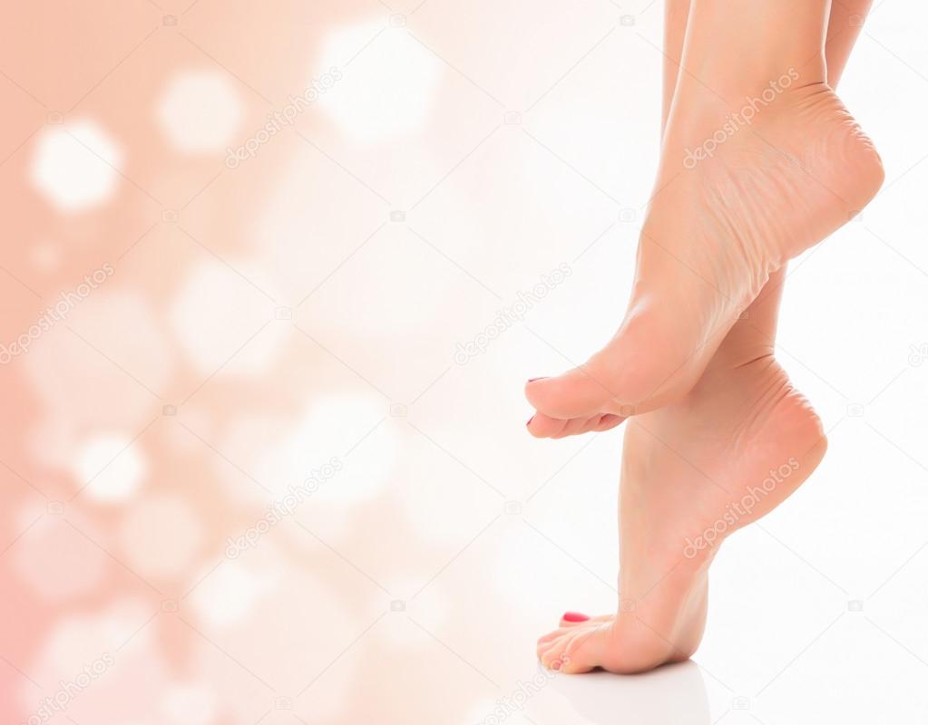 Female feet on pastel background