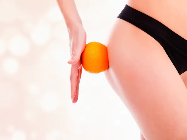 Figura feminina com um laranja, fundo borrado pastel — Fotografia de Stock