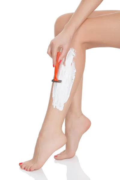 Woman shaving her legs, white background — Stock Photo, Image