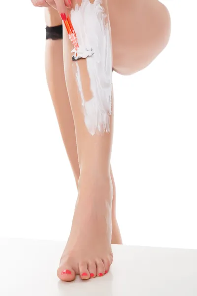 Mulher raspando as pernas, isolado no fundo branco . — Fotografia de Stock