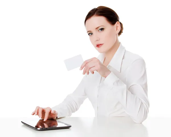 Mujer sentada con una tableta y sosteniendo una tarjeta de crédito —  Fotos de Stock