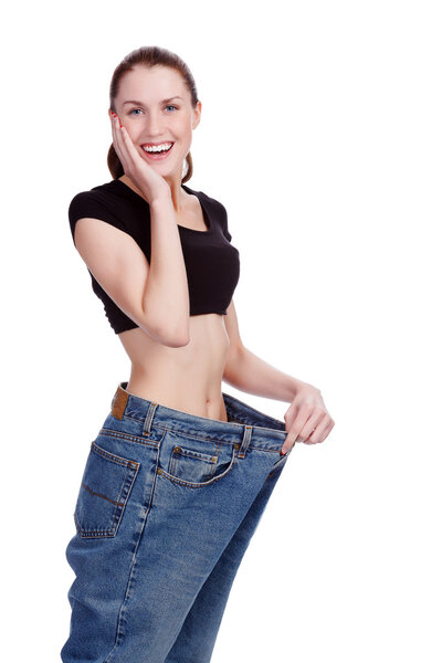 Surprised girl in big jeans. White background