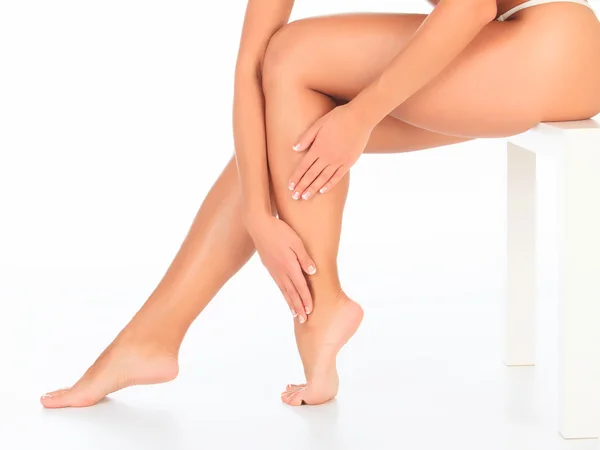 Kvinnliga ben och händer, vit bakgrund — Stockfoto
