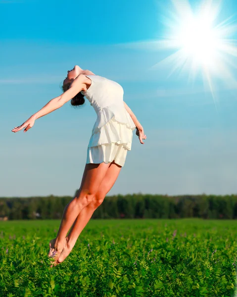 Mujer salta en un campo verde — Foto de Stock