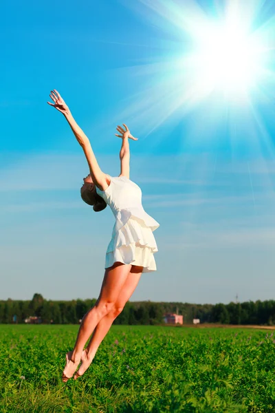 Woman jumps in a green field — Stock Photo, Image