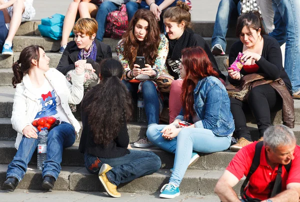 Company of young girls sitting on steps