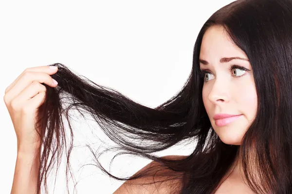 Brunette woman is not happy with her fragile hair — Stock Photo, Image