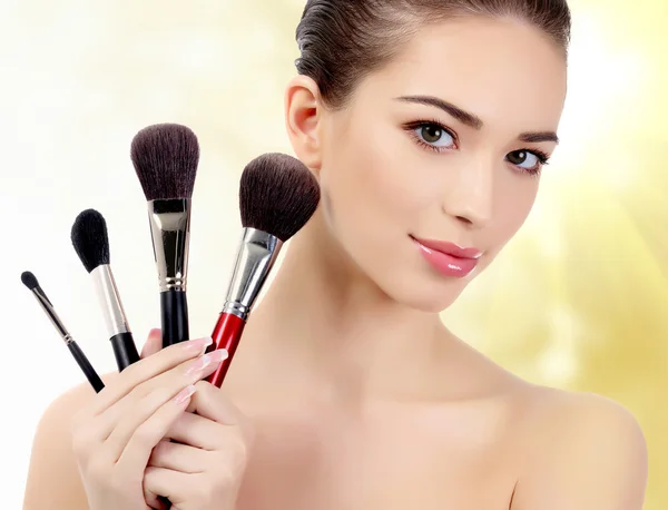 Pretty woman with cosmetic brushes — Stock Photo, Image