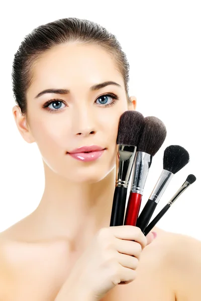 Vacker kvinna med kosmetikborstar, vit bakgrund — Stockfoto