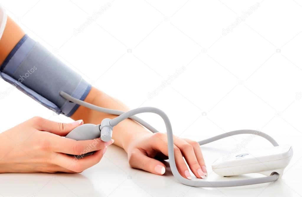 Female measures her blood pressure, white background, copyspace
