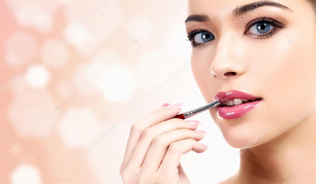 Woman applying lips makeup