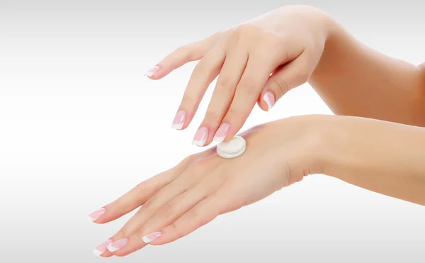 Γυναικεία χέρια με ένα moisturizer σε ανοιχτό γκρι φόντο — Φωτογραφία Αρχείου