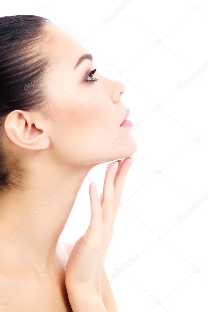 Young female touches her neck, white background, copyspace