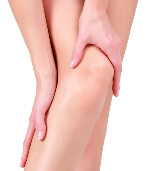Жінка тримає болісне коліно, ізольована на білому тлі — стокове фото