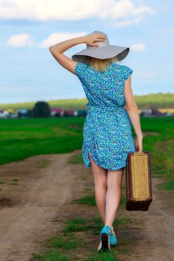 Bavullu yazlık elbiseli kadın.