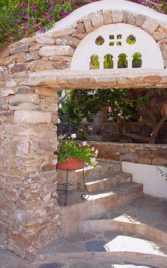 Bahçedeki çiçekleri ile kaba taş kemer