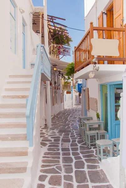 Calle estrecha de la isla griega con escaleras, flores y café de la calle . —  Fotos de Stock