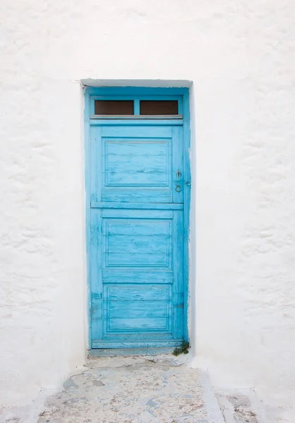 Oude geschilderde blauwe deur op de witgekalkte muur. achtergrond. typisch — Stockfoto