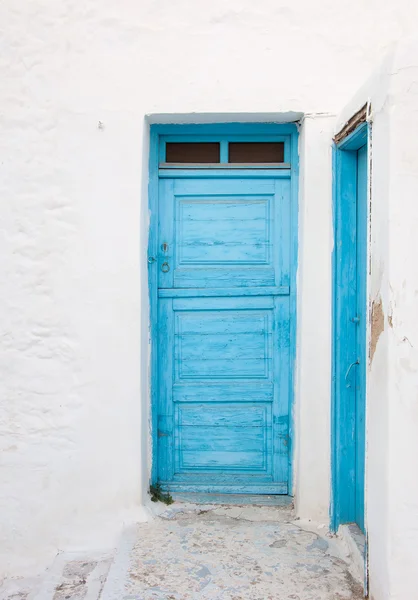 Porta azul pintada velha na parede caiada de branco. Contexto. Típico — Fotografia de Stock