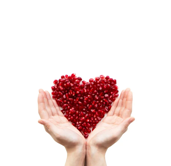 Pomegranate heart in hands — Stock Photo, Image