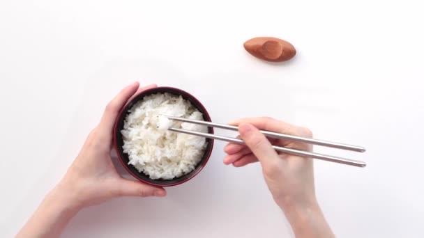 Mujer comiendo arroz con palillos . — Vídeo de stock