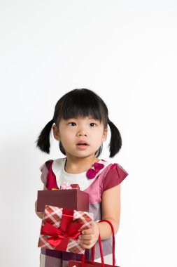 hediye kutusu ve çanta ile yürümeye başlayan çocuk kız