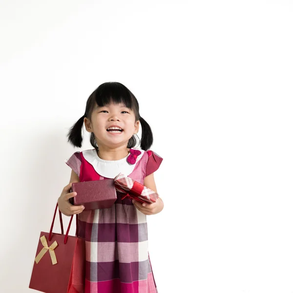 Peuter meisje met geschenkverpakking en tas — Stockfoto