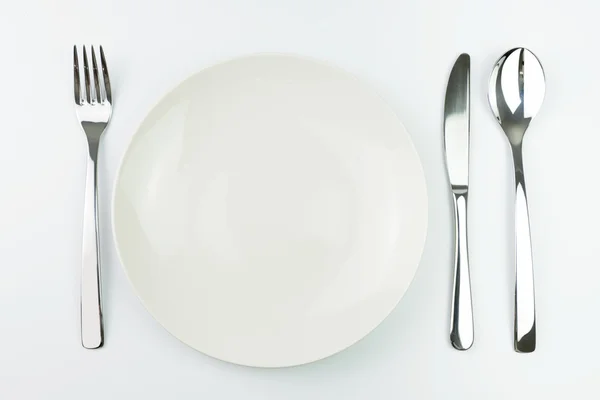 Assiette vide avec fourchette, couteau et cuillère — Photo
