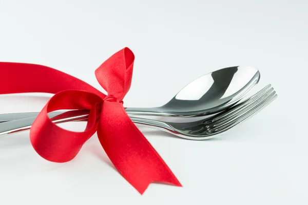 Fork, knife and spoon tied up with red ribbon — Stock Photo, Image