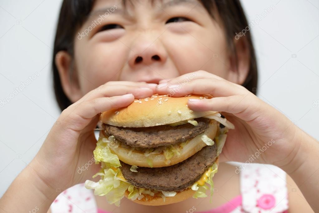 Kid eating big burger