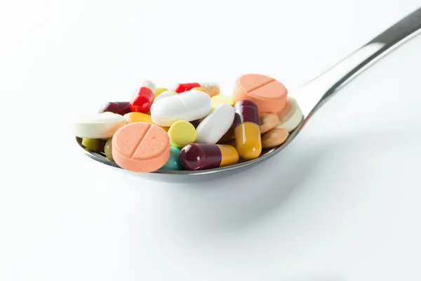 Spoon full of medicine pills — Stock Photo, Image