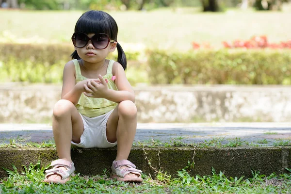 Μικρό παιδί που κάθεται στο πάρκο — Φωτογραφία Αρχείου