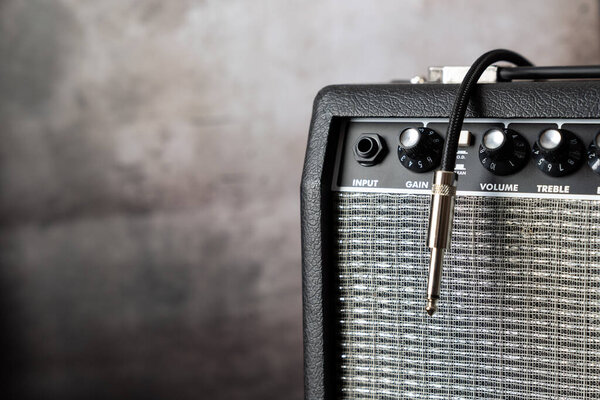 Close up of electric guitar amplifier with a audio cable. Shallow depth of field