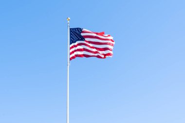Mavi gökyüzünde dalgalanan Amerikan bayrağı