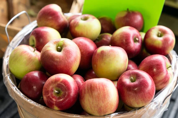 Apples sitting in a wooden basket for sales at the local farmer market