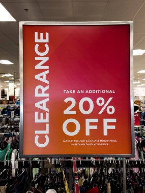 Mağazada kırmızı satış tabelası, yüzde 20 indirimli.