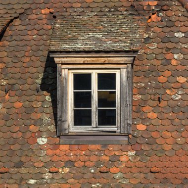 Window of attic on old tiled roof. clipart
