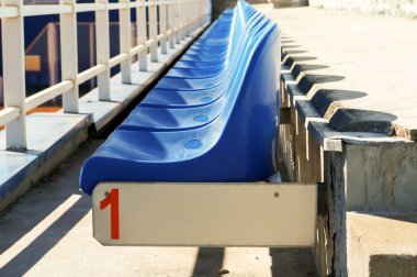 Açık tenis kortunda boş mavi seyirci koltukları.                                           