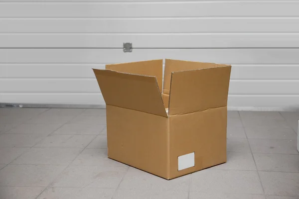 Open cardboard box in a garage — Stock Photo, Image