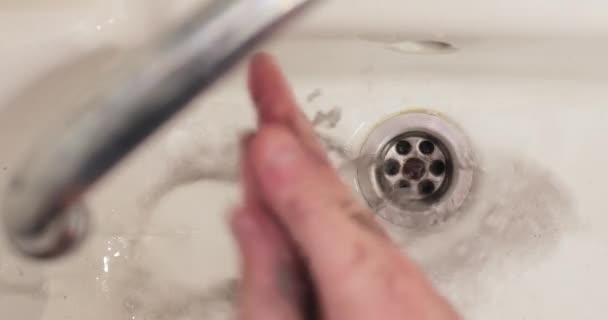 Washing hands in dirty bathroom sink, black water washed away — Stock Video