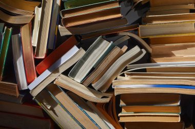 Tavan arasında dramatik loş ışıkta eski kitap yığınları, kitap duvarları, dağınık düzenleme