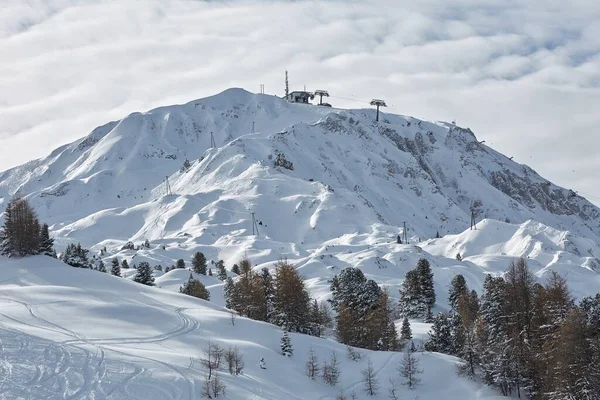 Лыжные трассы, величественный альпийский пейзаж со снегом и горным хребтом — стоковое фото