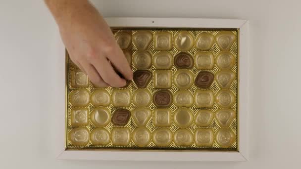 Vzít kousky bonbonů z krabice bonbonů, jen pár jich zbylo — Stock video