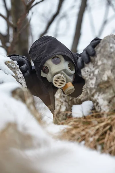 Gas mask man hiding in winter foresr — Stock Photo, Image