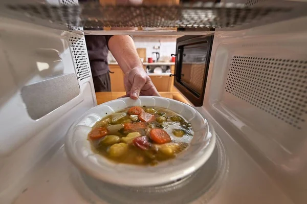 Aquecimento de alimentos em um forno de microondas — Fotografia de Stock