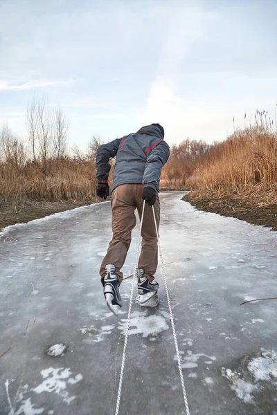 Człowiek łyżwiarstwo ciągnąc sanie na lodzie — Zdjęcie stockowe