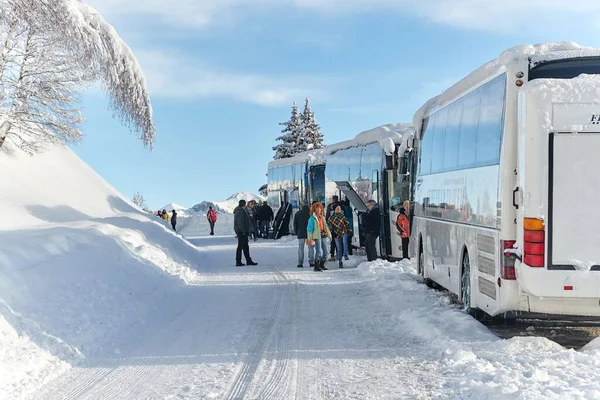 Skidåkning resa grupp med bussar i snöiga Alperna — Stockfoto