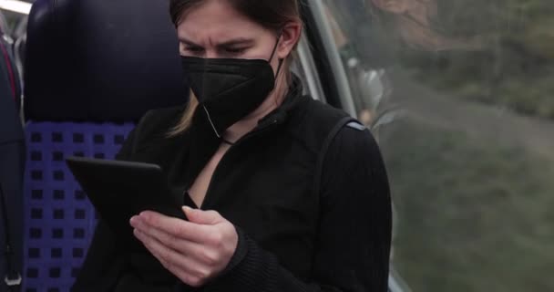 Kobieta w pociągu w masce i czytająca — Wideo stockowe