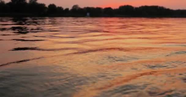 夕阳笼罩在平静的湖面上，波浪倒映在水面上 — 图库视频影像