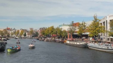 Amsterdam kanal trafiği merkezde turistik tur tekneleri.